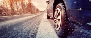 Automechaniker in der Werkstatt bei der Beratung zum Winterreifenwechsel – Motiv für Kfz-Vorsorge und Verkehrssicherheit im Winter